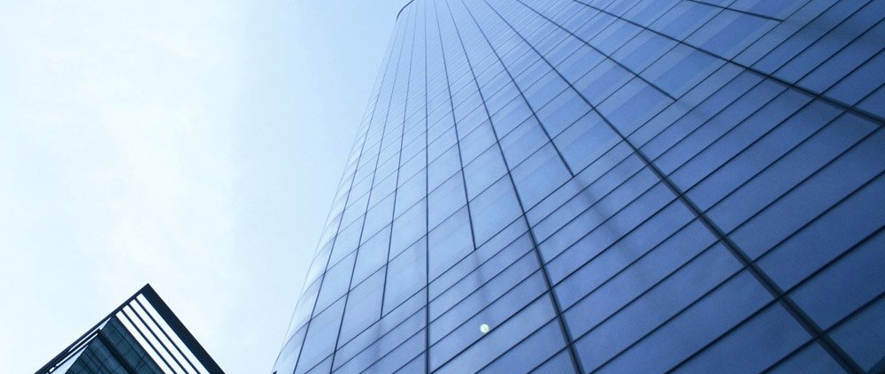 Skyscraper with glass facade against blue sky.