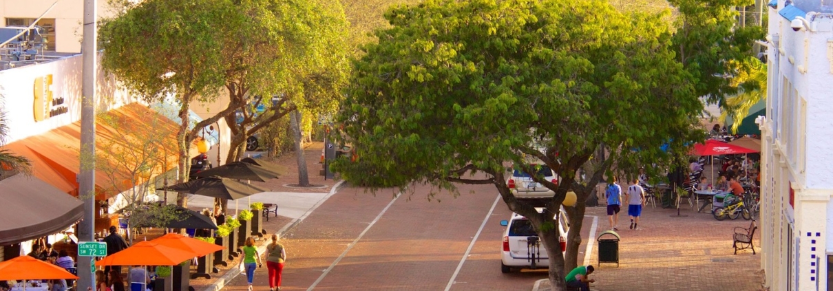 Street scene with trees and outdoor cafes.
