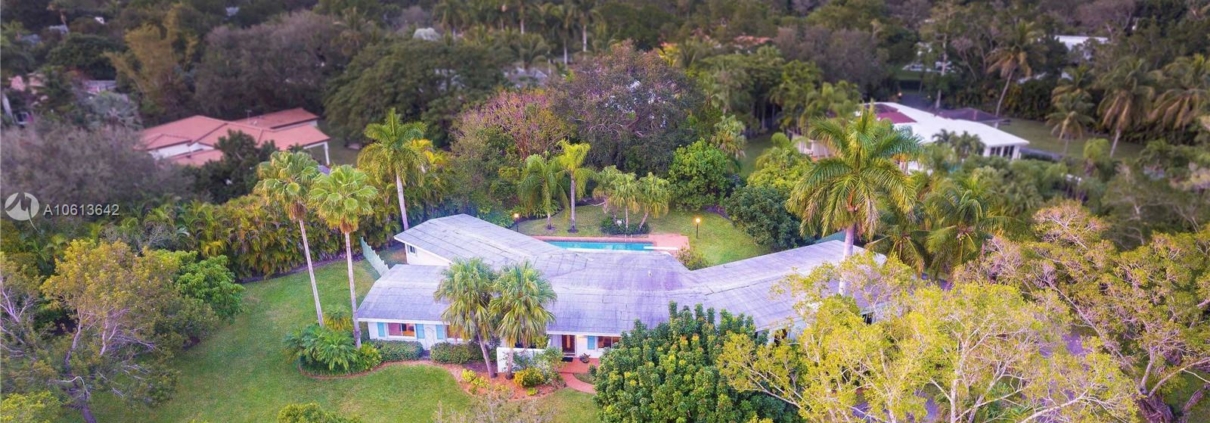 Aerial view of house surrounded by trees.