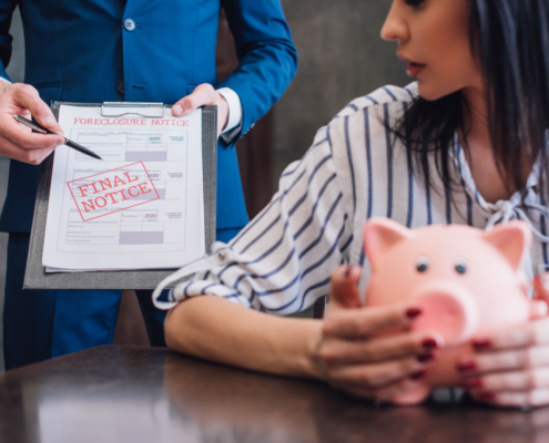 Woman holding piggy bank, facing foreclosure notice.