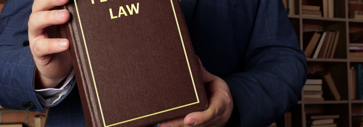 Man holding Florida law book in library.
