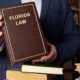Man holding Florida law book in library.